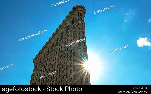 NEW YORK, NEW YORK, USA - SEPTEMBER 14, 2015: close up of the sun behind the flatiron building in manhatten, new york