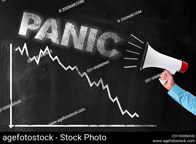 crash and panic at stock exchange and financial markets concept, hand holding megaphone with word PANIC against negative chart on blackboard