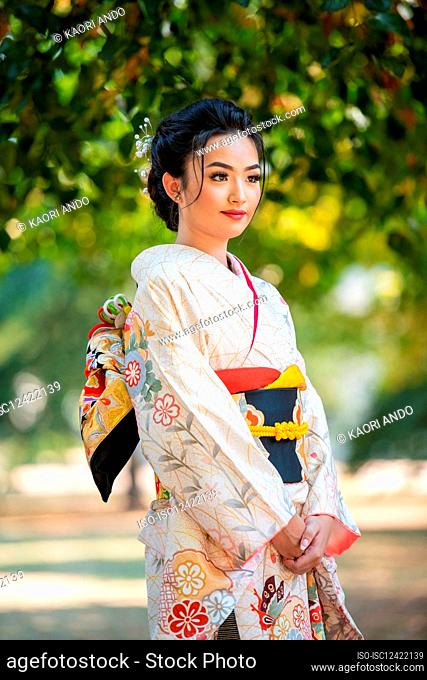Woman wearing kimono standing in park