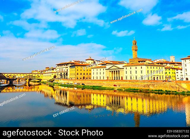 City view with Palazzo Vecchio tower, houses and Ponte Vecchio reflection in the river Arno, Florence, Italy