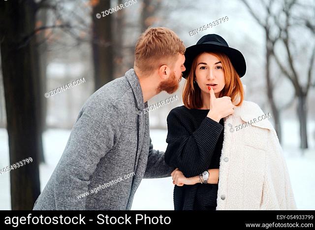 The guy and the girl are resting in the winter forest. Young couple walking in a winter park