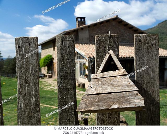Handmade wooden birdhouse at entrance door of a Masia (typical catalan farmhouse). Prats de Lluçanès countryside. Osona region