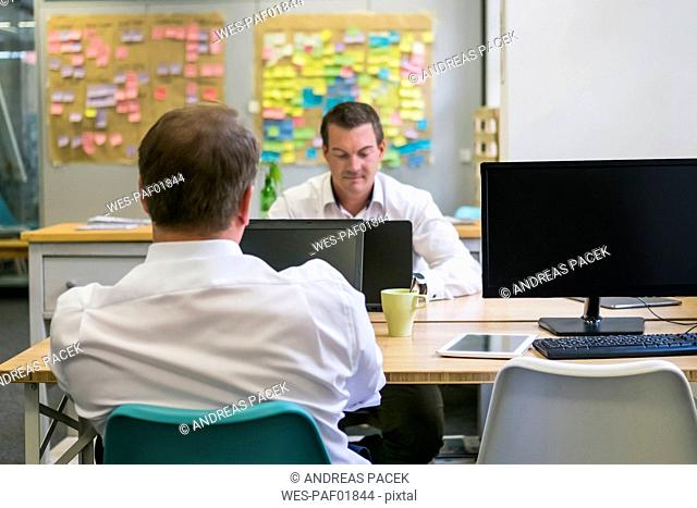 Two businessmen working at desk in office