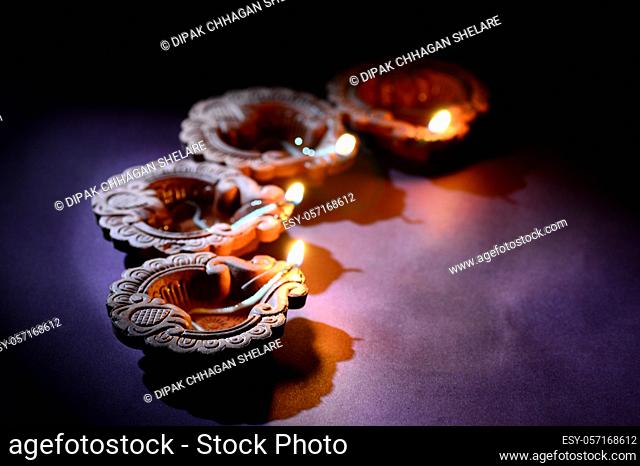 Colorful clay Diya (Lantern) lamps lit during Diwali celebration. Greetings Card Design Indian Hindu Light Festival called Diwali