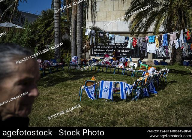 24 November 2023, Israel, Tel Aviv: A group of chairs with Israelis flags and teddy bears as Israelis gather at the Museum square as they anticipate for the...