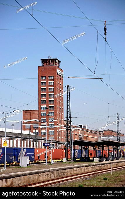 Rüsselsheim, Deutschland - April 11, 2018: Güterzüge mit beladenen Containern stehen vor den Industriegebäuden der Opelwerke auf den Schienen am 11