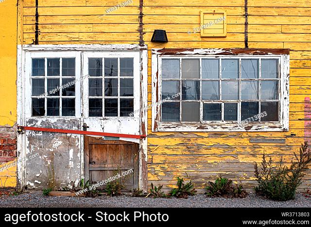 Glass windows and door with lock on yellow household wooden house