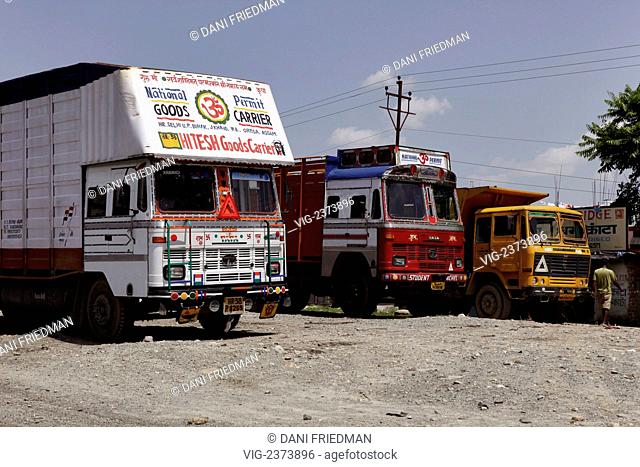 Colourful painted trucks parked in the city of Siliguri in West Bengal, India. These often religiously decorated goods carriers are a characteristic of Indian...