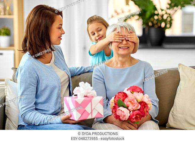mother and daughter greeting grandmother at home