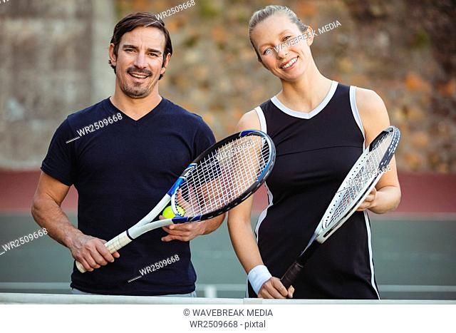 Portrait of two tennis players standing with racket