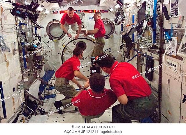 Five of the six Expedition 34 crew members are pictured in the Kibo laboratory of the International Space Station. Pictured clockwise (from bottom center) are...