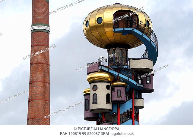 19 August 2019, Bavaria, Abensberg: The 35 metre high Hundertwasser Tower stands next to a chimney of the Kuchelbauer brewery
