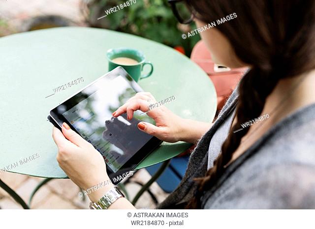 High angle view of woman working on tablet in coffee break at greenhouse