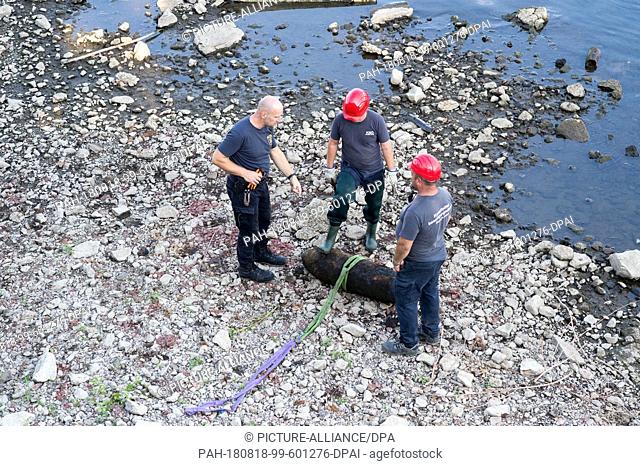 18 August 2018, Germany, Magdeburg: Employees of the explosive ordnance disposal service stand next to a defused World War II bomb