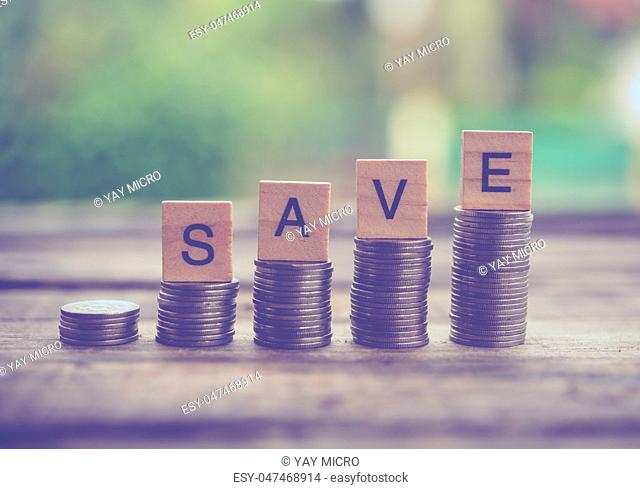 The coins are staggered and have ""SAVE"" wooden letters placed on the wood floor. - Savings Ideas for Increasing Volume