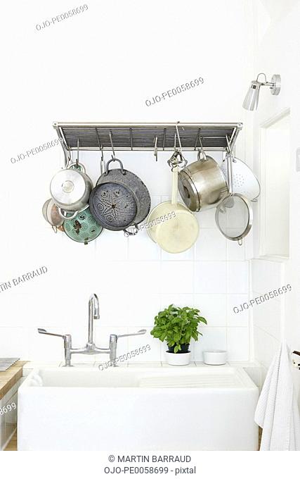 Kitchen sink with cooking pots hanging overhead