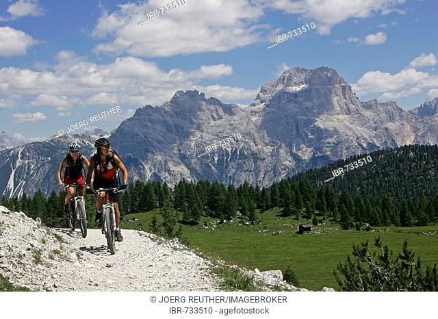 Female mountain bikers at Croda da Lago, Sorapis Massif in the background, Dolomites, Northern Italy, Europe