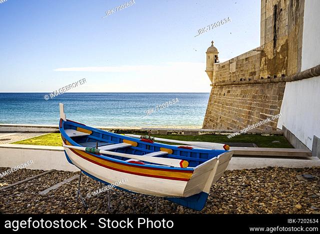 The wooden traditional boat and Saint James Fortress on the beach of Sesimbra, Lisbon Metropolitan Area, Portugal, Europe