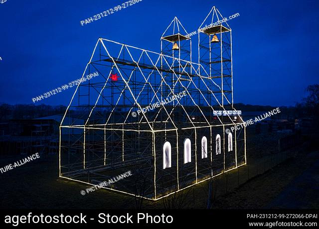 12 December 2023, Mecklenburg-Western Pomerania, Fahrbinde: The Christmas church erected by scaffolders in the last few days and illuminated with fairy lights...