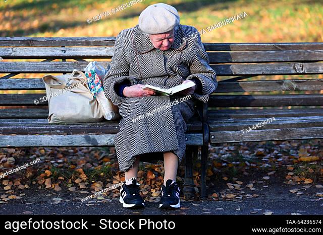 RUSSIA, MOSCOW - NOVEMBER 1, 2023: An elderly woman reads a book sitting on a bench in the Tsitsin Main Botanical Garden. Sofya Sandurskaya/TASS