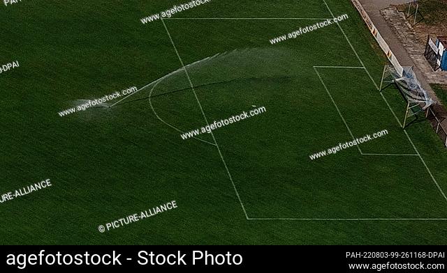 03 August 2022, Brandenburg, Oranienburg: A water sprinkler is in use at a soccer field in Oranienburg, Brandenburg, Germany