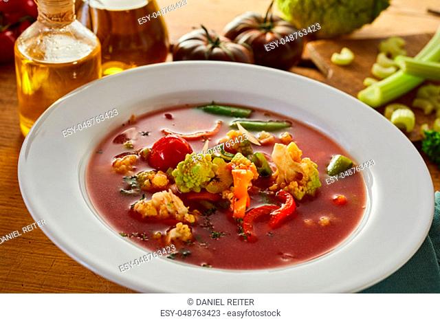 Italian minestrone soup with assorted fresh vegetables including celery, tomato, carrot and cauliflower in a rich broth