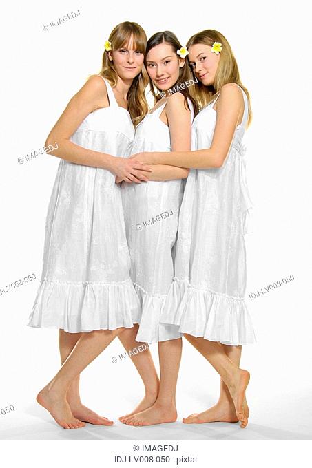 Portrait of three young women hugging each other