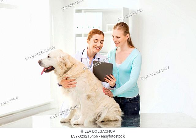 medicine, pet, health care, technology and people concept - happy woman with golden retriever dog and veterinarian doctor holding tablet pc computer at vet...