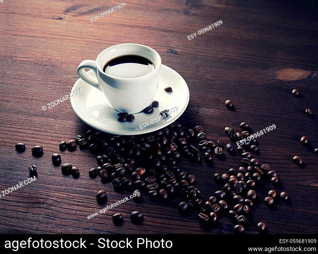 Photo of coffee cup and coffee beans on wooden background