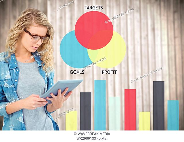 Woman with tablet against colourful graphs and blurry wood panel
