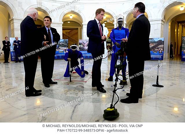 Prince Harry (2-R) of Wales is shown a ground penetrating radar, a tool used for detecting land mines, during a tour of a HALO Trust photo exhibit on landmines...