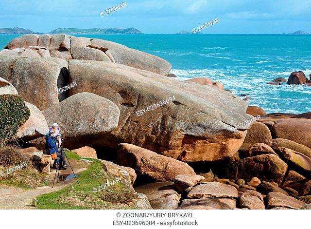 Ploumanach coast view and family on stony bench (Brittany, France)