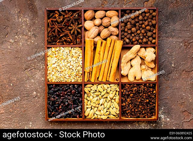 Seasoning in wooden box as background, top view with copy space