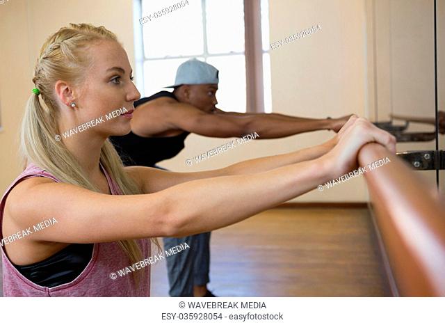 Dancers stretching on barre