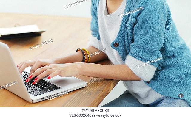 Young creative woman working on her laptop in a bright work space