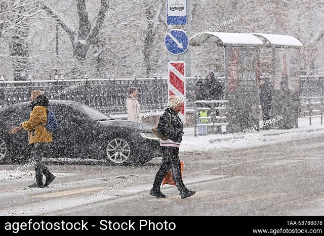 RUSSIA, YEKATERINBURG - OCTOBER 24, 2023: People cross Prospekt Lenina Street during a snowfall. Donat Sorokin/TASS