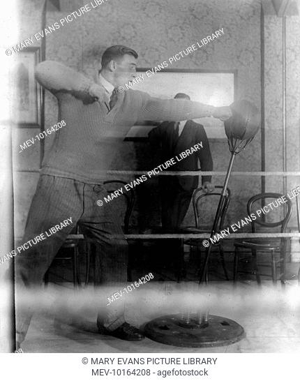 Italian boxer, Primo Carnera, World Heavyweight Champion 1933 - 1934. Here 'practising' whilst dressed in ordinary clothes