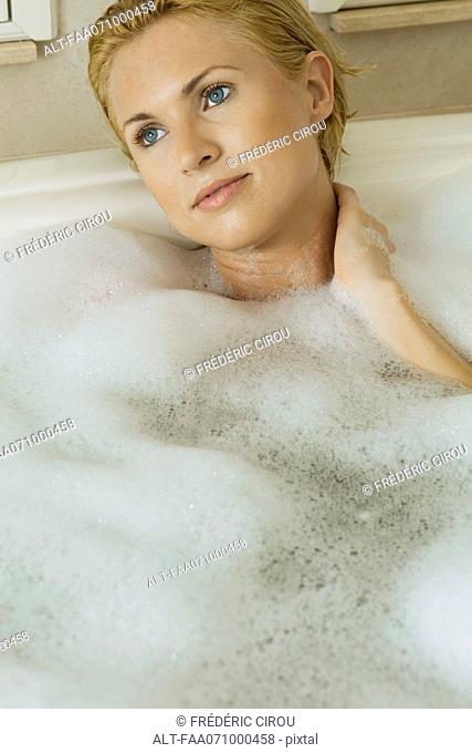Mid-adult woman unwinding in bubble bath, portrait