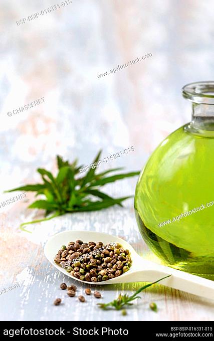 Bottle of organic hemp oil, leaves and seeds