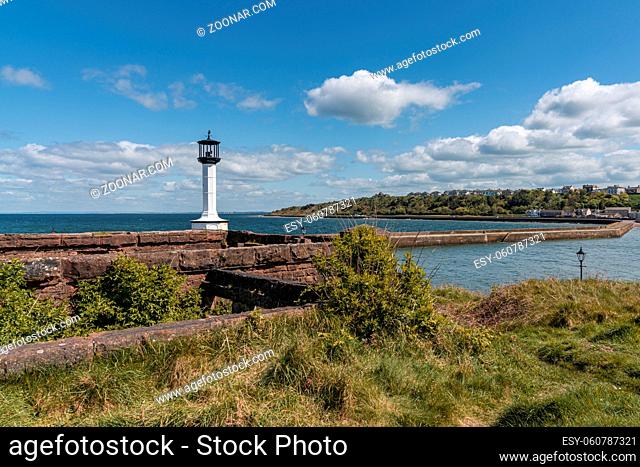 Maryport, Cumbria, England, UK - May 04, 2019: The Old Maryport Lighthouse, with the pier and the River Ellen