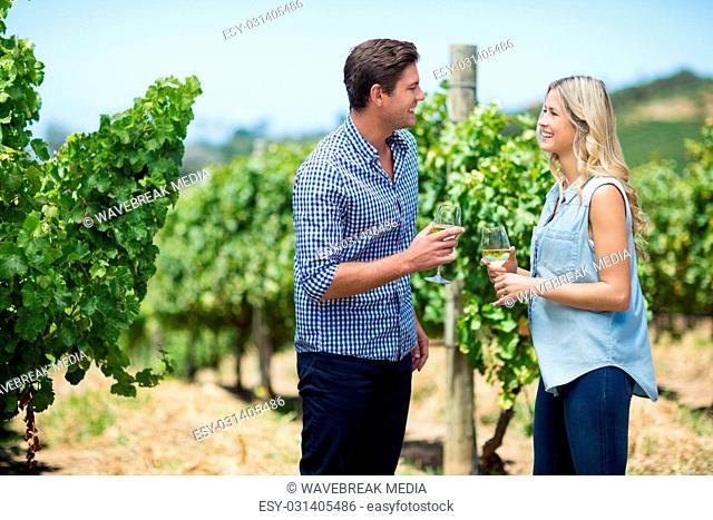 Happy young couple looking at each other while holding wineglasses