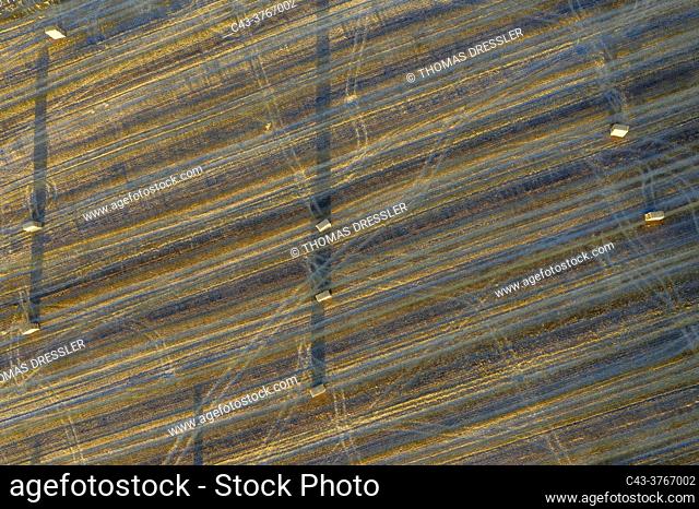 Bales of straw and abstract patterns in cornfield after wheat harvest. Prominent the tractor wheel ruts. In the Campiña Cordobesa