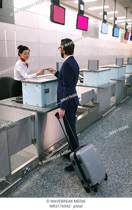 Airline check-in attendant handing passport to commuter