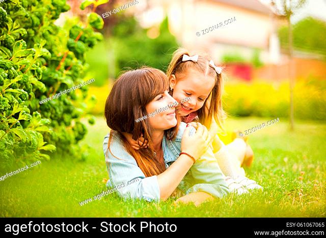 Young mother and daughter having fun together outdoors. Happy mother's day