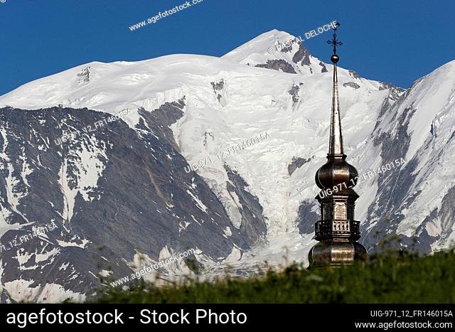 Baroque clock tower of Saint Nicolas church against Mont-Blanc massif in the french Alps. Combloux. France