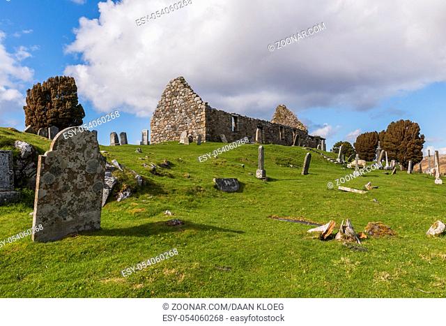 Loch Cill Chriosd, Scotland - May 7, 2015: Graveyard on the Isle of Skye in the Highlands of Scotland with lake, snow and piles of stone