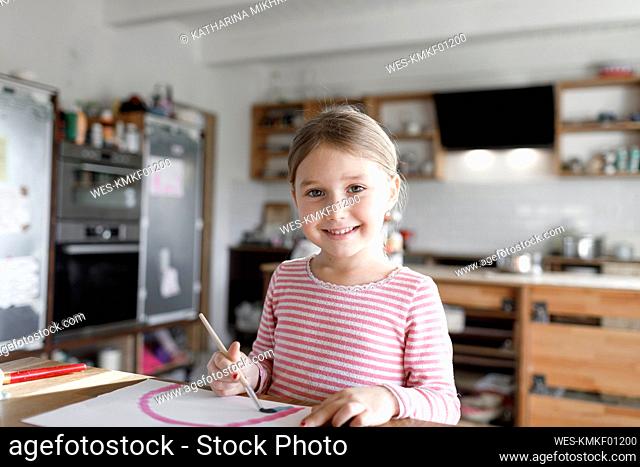 Portrait of girl painting at home