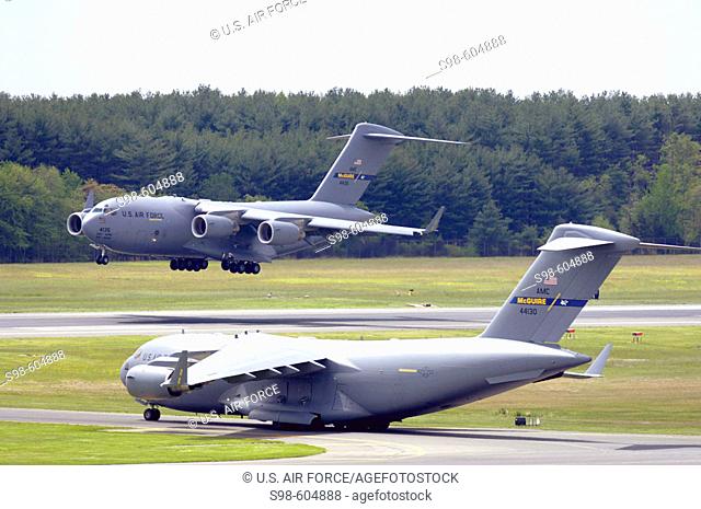 A C-17 Globemaster III from the 305th Air Mobility Wing at McGuire Air Force Base, N.J., performs touch and go landings while another C-17 prepares for take-off...
