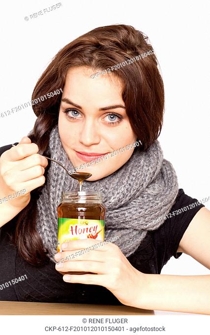 A beautiful young woman, lady, girl, cold, runny nose, headache, tea, honey, spoon, scarf