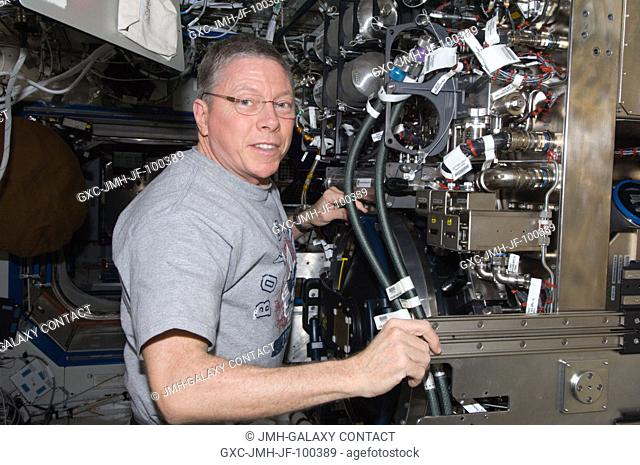 NASA astronaut Mike Fossum, Expedition 29 commander, works on the Combustion Integrated Rack (CIR) in the Destiny laboratory of the International Space Station